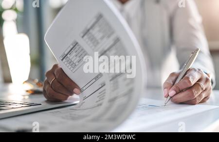 Passez en compte chaque détail avant de signer. une femme d'affaires méconnue qui remplit ses documents administratifs dans son bureau. Banque D'Images