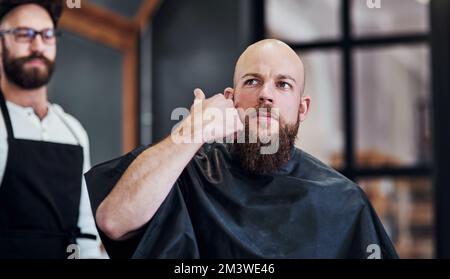 La vie est meilleure avec une barbe. un beau jeune homme qui tond sa barbe et l'alignera dans un salon de coiffure. Banque D'Images