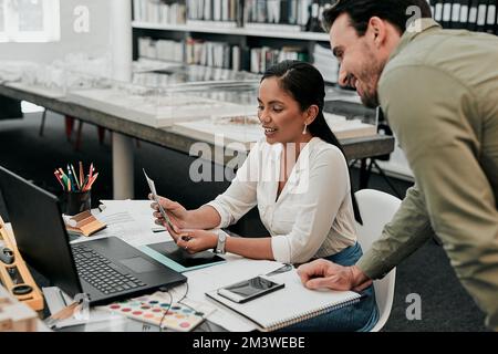 Vous pouvez peut-être m'aider à choisir la couleur à utiliser. deux jeunes architectes travaillent ensemble dans un bureau moderne. Banque D'Images