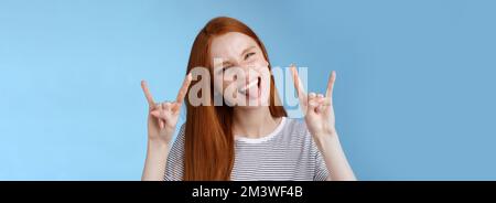 Oser insouciance ludique excitée bonne-regardant drôle redhead fille ayant le plaisir montrez l'affaissement de la languette faites de la grimace ravie faire du métal lourd rock-n-roll signe Banque D'Images