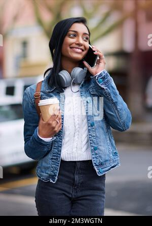 Restez en contact. une belle jeune femme qui parle sur son téléphone portable pendant qu'elle est en ville. Banque D'Images