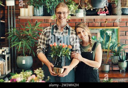 Nous vous avons couvert pour toutes les occasions. Portrait court de deux jeunes propriétaires d'entreprise debout dans leur fleuriste tout en tenant un bouquet de Banque D'Images