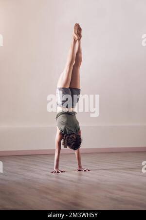 S'étirer au-delà des limites. Prise de vue en longueur d'une jeune femme sportive faisant une main debout en studio. Banque D'Images