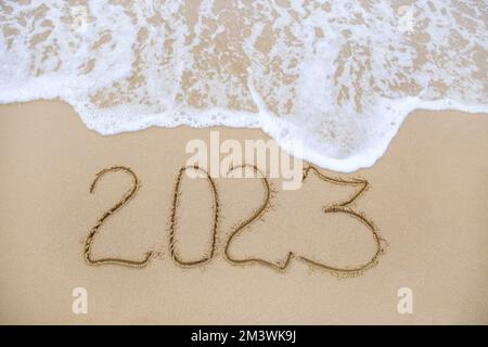 2023 ans écrit sur la plage de sable. Vue de dessus. Pose à plat. Banque D'Images