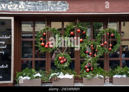 Szentendre, Hongrie - 30 novembre 2022 : décorations de Noël sur une fenêtre de restaurant dans une rue Szentendre, Hongrie. Banque D'Images