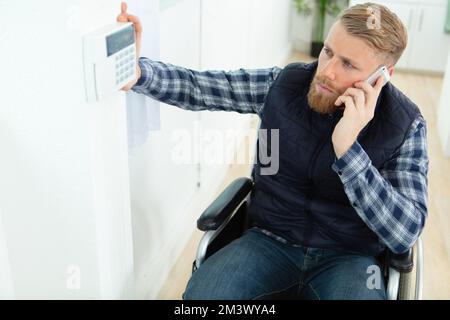 homme handicapé en fauteuil roulant au téléphone Banque D'Images