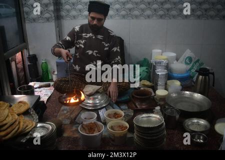 16 décembre 2022, Srinagar, Jammu-et-Cachemire, Inde: Un commerçant verse de l'huile de cuisson chaude sur une assiette contenant un plat à viande, connu localement sous le nom de 'Harisa', avant du servir à ses clients à Srinagar, le 16 décembre 2007. Harisa est un repas préféré que Kashmiris mange tôt le matin en hiver dans des magasins spécialement aménagés appelés la fourgonnette Harisa. (Credit image: © Mubashir Hassan/Pacific Press via ZUMA Press Wire) Banque D'Images