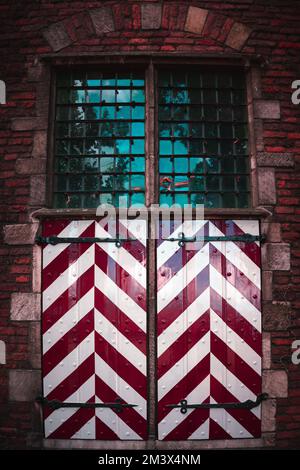 Vieilles fenêtres anciennes avec de petits carreaux carrés au-dessus des volets de fenêtres Banque D'Images