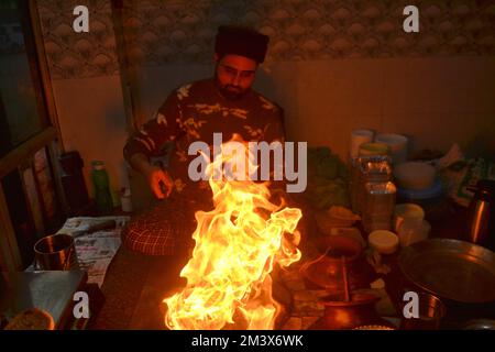 Srinagar, Inde. 16th décembre 2022. Le gérant de magasin verse de l'huile de cuisson chaude sur une assiette contenant un plat à viande, connu localement sous le nom de « Harisa », avant du servir à ses clients à Srinagar, le 16 décembre 2007. Harisa est un repas préféré que Kashmiris mange tôt le matin en hiver dans des magasins spécialement aménagés appelés la fourgonnette Harisa. (Photo de Mubashir Hassan/Pacific Press) crédit: Pacific Press Media production Corp./Alay Live News Banque D'Images