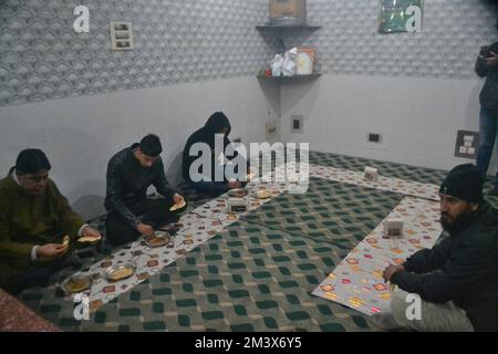 Srinagar, Inde. 16th décembre 2022. Les hommes cachemiriens mangent 'Harisa' dans un magasin tôt le matin à Srinagar, Cachemire contrôlé par l'Inde, dimanche 16 décembre 2022. Harisa est un plat d'hiver qui est vendu tôt le matin dans des magasins spécialement configurés, appelé Harisa Van. (Photo de Mubashir Hassan/Pacific Press) crédit: Pacific Press Media production Corp./Alay Live News Banque D'Images