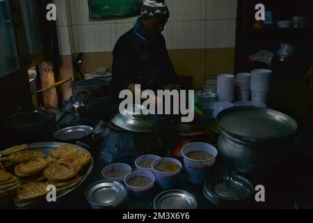 Srinagar, Inde. 16th décembre 2022. Le gérant de magasin verse de l'huile de cuisson chaude sur une assiette contenant un plat à viande, connu localement sous le nom de « Harisa », avant du servir à ses clients à Srinagar, le 16 décembre 2007. Harisa est un repas préféré que Kashmiris mange tôt le matin en hiver dans des magasins spécialement aménagés appelés la fourgonnette Harisa. (Photo de Mubashir Hassan/Pacific Press) crédit: Pacific Press Media production Corp./Alay Live News Banque D'Images