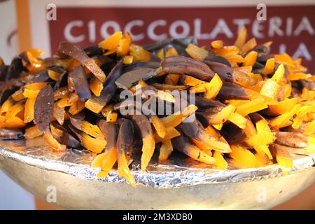 Des peaux d'orange confites trempées au chocolat noir sont exposées dans un bol à une cioccolateria en Italie Banque D'Images