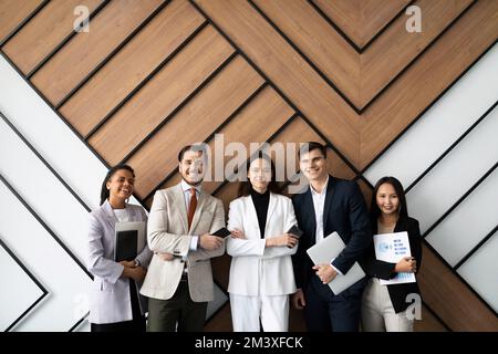 le groupe de travailleurs multiraciaux souriants, jeunes et vieux, se pose ensemble comme une ressource humaine Banque D'Images