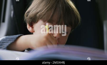 Dessin de visage d'enfant focalisé sur le papier. Un petit garçon concentré faisant des devoirs tenant le crayon de coloriage. Enfant artistique étudiant Banque D'Images