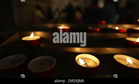 CandleLights à l'intérieur de la cathédrale catholique brûlant dans la prière au ralenti. Concept d'espoir et de foi Banque D'Images