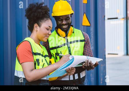 Le travailleur de l'équipe douanière du couple afro-américain travaillant avec la liste de contrôle ordre d'expédition à la cour de conteneur de port apprécient le travail sourire heureux Banque D'Images