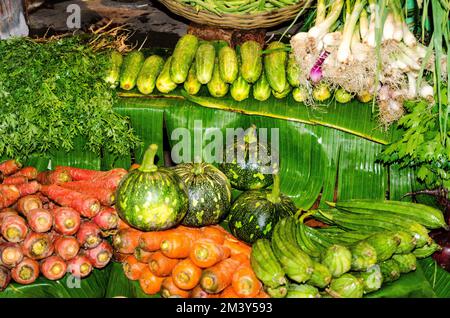 Oignons, concombres, carottes et melons à vendre sur un marché de légumes dans les rues Banque D'Images