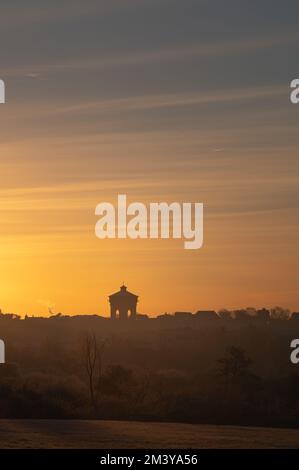 Vue sur la tour d'eau Jumbo de Colchester depuis une distance. Silhouettes des bâtiments au soleil du matin. Lever le soleil sur Colchester, Essex. Banque D'Images