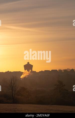 Vue sur la tour d'eau Jumbo de Colchester depuis une distance. Silhouettes des bâtiments au soleil du matin. Lever le soleil sur Colchester, Essex. Banque D'Images