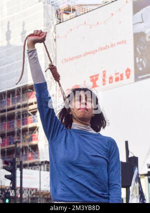 Londres, Royaume-Uni. 17th décembre 2022. Un manifestant effectue une danse avec un nœud autour de son cou. Un groupe de femmes a organisé une manifestation et un spectacle à Piccadilly Circus pour protester contre les exécutions signalées de manifestants anti-gouvernementaux en Iran. Les activistes ont attaché des cordes autour de leur cou et ont couvert leurs mains dans du sang factice. Credit: Vuk Valcic/Alamy Live News Banque D'Images