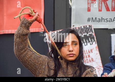 Londres, Royaume-Uni. 17th décembre 2022. Un groupe de femmes a organisé une manifestation et un spectacle à Piccadilly Circus pour protester contre les exécutions signalées de manifestants anti-gouvernementaux en Iran. Les activistes ont attaché des cordes autour de leur cou et ont couvert leurs mains dans du sang factice. Credit: Vuk Valcic/Alamy Live News Banque D'Images