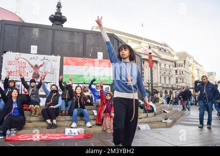 Londres, Royaume-Uni. 17th décembre 2022. Un manifestant effectue une danse avec un nœud autour de son cou. Un groupe de femmes a organisé une manifestation et un spectacle à Piccadilly Circus pour protester contre les exécutions signalées de manifestants anti-gouvernementaux en Iran. Les activistes ont attaché des cordes autour de leur cou et ont couvert leurs mains dans du sang factice. Credit: Vuk Valcic/Alamy Live News Banque D'Images