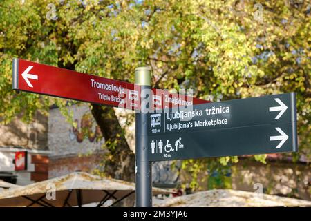 Panneaux pour les sites touristiques dans la rue à Ljubljana, Slovénie. Au célèbre pont triple, toilettes et marché. Banque D'Images