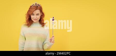 femme souriante à tête rouge dans la couronne de reine avec baguette magique, wish. Femme isolée visage portrait, bannière avec espace de copie. Banque D'Images