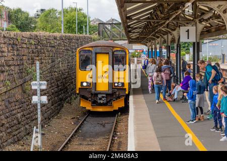 Touristes et voyageurs sur un quai avec un train arrivant de Falmouth à la gare de Truro. Banque D'Images