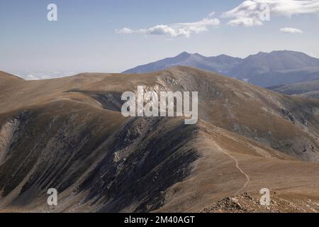 Une vue depuis le pic Bastitents d'un paysage montrant des montagnes sous ciel bleu nuageux dans les Pyrénées Banque D'Images