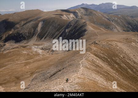 Une vue depuis le pic Bastitents des personnes marchant dans un paysage montrant les montagnes dans les Pyrénées Banque D'Images