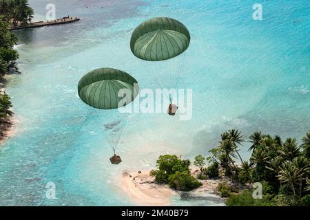 Île de Murilo, États fédérés de Micronésie. 06 décembre 2022. Le transport humanitaire en parachute vers un lagon à partir d'un avion Hercules C-130H de la Force aérienne japonaise d'autodéfense affecté au 401st Escadron de transport aérien tactique, lors de l'opération Christmas Drop, 6 décembre 2022, sur l'île de Murilo, Chuuk, Micronésie. L'opération Christmas Drop est la plus ancienne mission humanitaire et de secours en cas de catastrophe qui livre 71 000 livres de nourriture, de cadeaux et de fournitures pour aider les communautés insulaires éloignées du Pacifique Sud. Crédit : Yasuo Osakabe/US Airforce photo/Alay Live News Banque D'Images