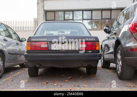 Arrière de la BMW noire 318i (1989) stationnement sur un parking en ville. Banque D'Images