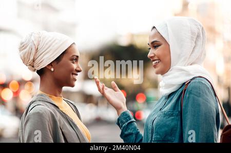 Que devrions-nous faire ensuite, selon vous. une jeune femme attirante portant un hijab et parlant avec sa femme en visitant la ville. Banque D'Images