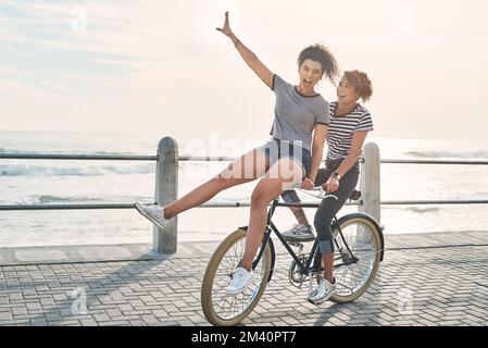 Étaient tout au sujet de la vie dans le moment. deux amis s'amusent à faire du vélo le long de la côte. Banque D'Images