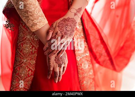 Le design Mehndi fait tourner les têtes. une femme méhendi non reconnaissable peint sur ses mains le jour de son mariage. Banque D'Images