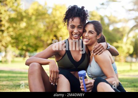 Nous sommes les meilleurs amis. Portrait court de deux jeunes femmes attrayantes assises près l'une de l'autre et souriant dans le parc. Banque D'Images