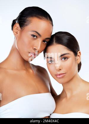 Ne perdez jamais votre unicité et vous ne perdrez jamais votre beauté. Photo de studio de jeunes femmes qui se posent sur un fond gris. Banque D'Images