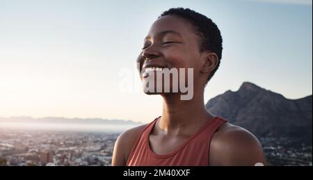 Femme noire, fitness et sourire pour la randonnée en montagne, l'entraînement ou l'exercice dans la nature en plein air. Bonne femme afro-américaine souriante pour un cardio sain Banque D'Images