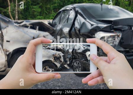 femme utilisant un smartphone prendre une photo de l'accident de voiture sur la route Banque D'Images