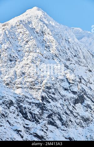 Quelques personnes au sommet du mont Snowdon, par une journée d'hiver ensoleillée et nuageux. Banque D'Images