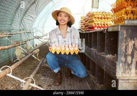Femme asiatique, oeufs de poulet ou plateau pour les ventes agricoles, l'exportation agricole ou la croissance durable succès. Portrait, sourire ou éleveur de volaille heureux et Banque D'Images