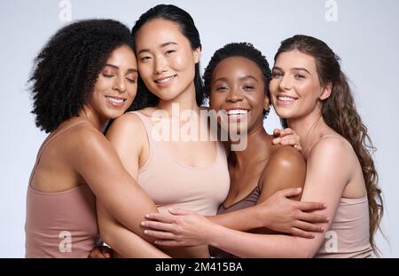 Soins de la peau, soutien et diversité des femmes avec un câlin pour la collaboration de maquillage, cosmétiques et beauté sur un fond de studio. Affection, heureux et Banque D'Images