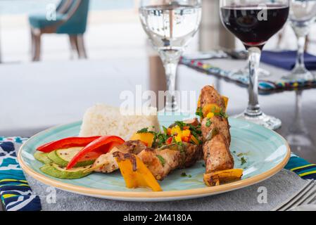 Poulet shish kebab repas à la carte avec du riz blanc à la vapeur à la table du restaurant Banque D'Images