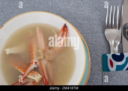 Gros plan sur la soupe de crabe et de fruits de mer entrée à la carte dans un bol avec couverts à la table du restaurant Banque D'Images