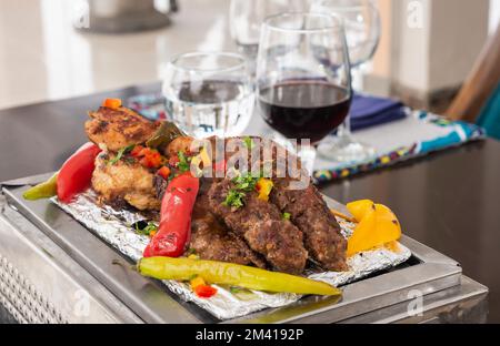 Repas à la carte avec viande grillée sur une plaque chaude à la table du restaurant Banque D'Images