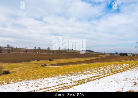 Terrain et agriculture terre dans la neige. Regardez le champ labouré et la prairie Banque D'Images