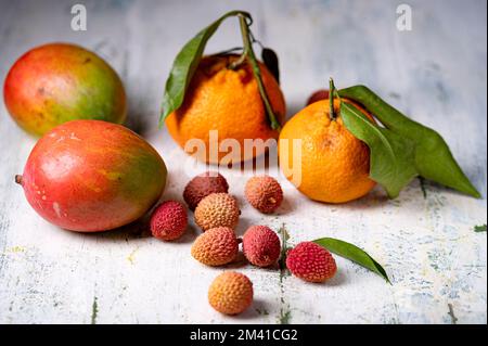 Une vie encore avec des lychees tangerines et mangues sur la table de sorbde Banque D'Images