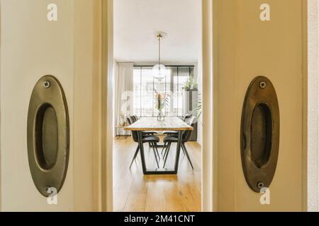 une porte ouverte menant à une salle à manger avec deux chaises et une table dans la zone d'entrée de la porte Banque D'Images