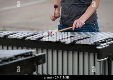 en début de soirée, un percussionniste répète pour un spectacle de groupes de marche Banque D'Images